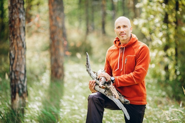 Tourist man gathering wood for a fire