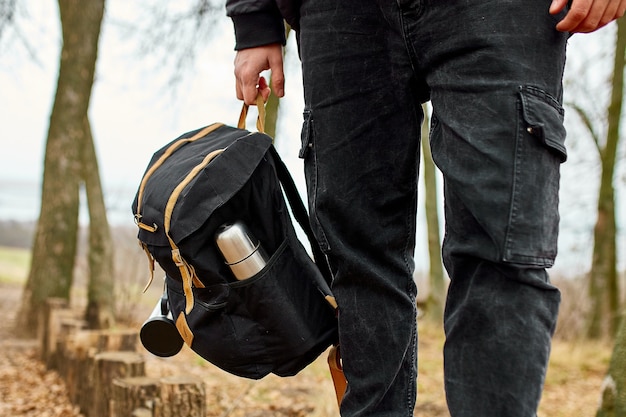 Tourist man looking into his backpack Travel concept Autumn background landscape