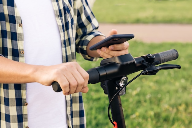 Tourist man take electric kick scooter in sharing parking lot tourist phone application