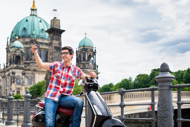 写真 ベルリンのベスパとの観光ツアー中に自分撮りをしている観光客の男