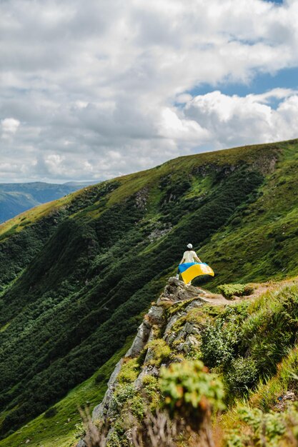 A tourist on the mountains with a ukrainian flag