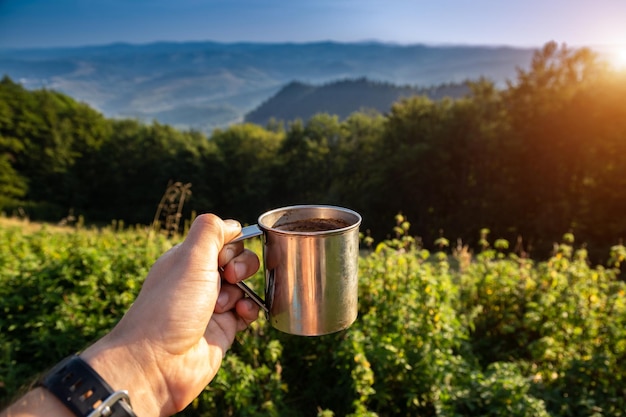 Tourist mug in the mountains with coffee Holidays in the Carpathian mountains