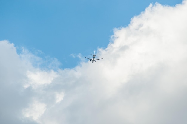 観光飛行機は青い空を背景に雲の中を飛ぶ