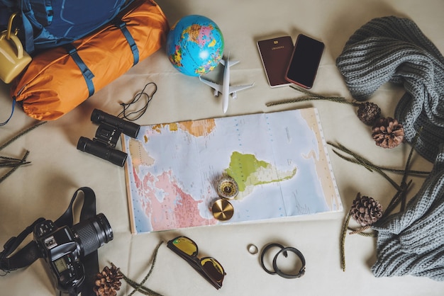 Foto vacanze di pianificazione turistica con l'aiuto della mappa del mondo con altri accessori da viaggio in giro.