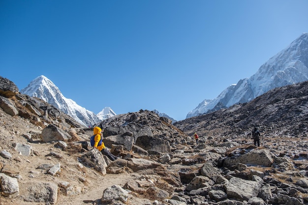 Tourist and porters walking on dirt road in nepal to everest\
base camp khumbu glacier way to mt everest base camp khumbu valley\
sagarmatha national park nepal