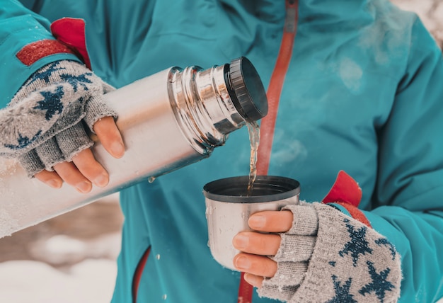 Photo tourist pouring tea from thermos