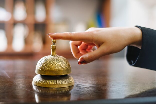 The tourist presses the bell at the hotel reception