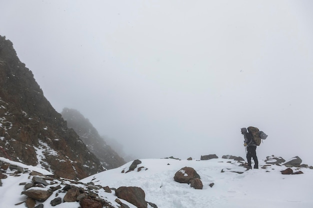 観光客は冬の日に雪山の頂上に到達します