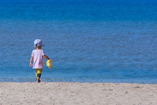 Tourist season a child walks on the beach vacation by the sea