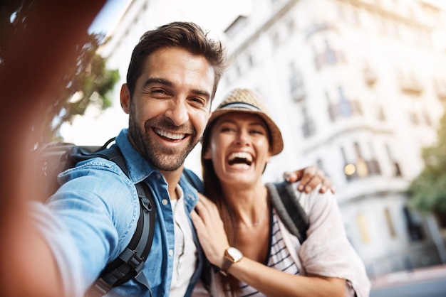 Foto selfie turistico e coppia felice per viaggiare sulla strada della città per la memoria e la felicità delle vacanze volto di uomo e donna all'aperto per un viaggio avventuroso all'aperto o una vacanza per la libertà o un ritratto divertente