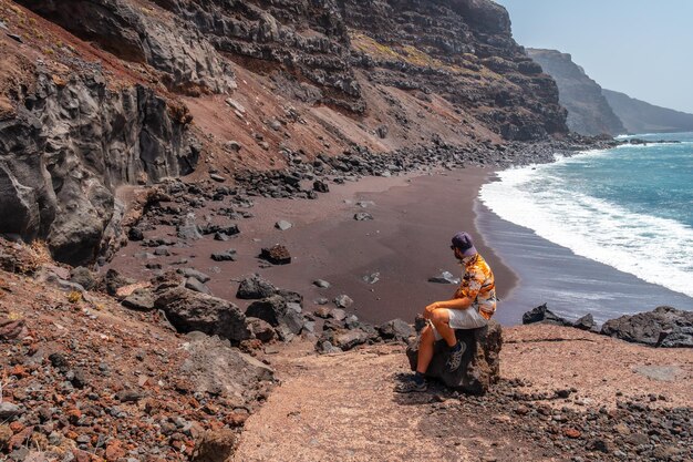 A tourist sitting on the Verodal beach on El Hierro Island Canary Islands