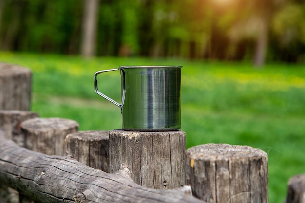 Tourist steel cup in the summer forest outdoors