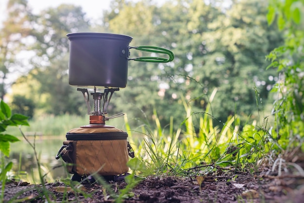 Tourist stove gas for camping and recreation against the backdrop of nature and the lake