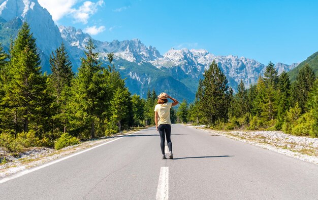 A tourist in summer walking on the road in the Valbona valley enjoying the freedom Theth national park Albanian Alps Valbona Albania