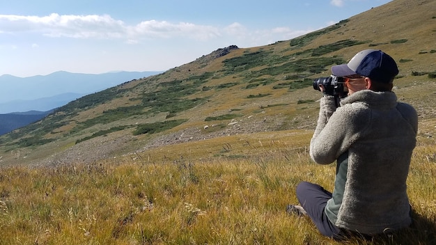 Tourist taking photographs on mountain