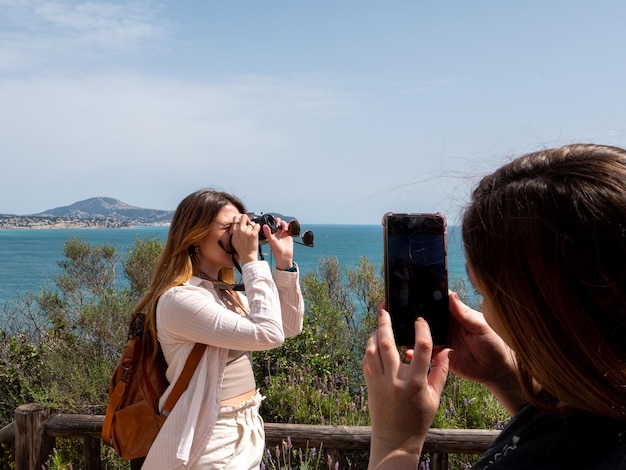 写真 海を背景に写真を撮る観光客