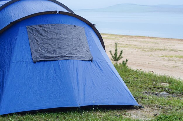 Tourist tent in blue stands in the forest