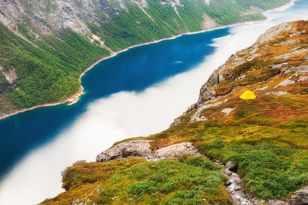 ノルウェーの湖の近くの山でキャンプする観光テント