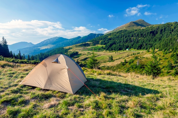 Tourist tent in mountains on a summer sunny day