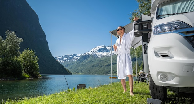 Tourist on a Vacation Staying with a Cup of Coffee in Front of His Camper Van