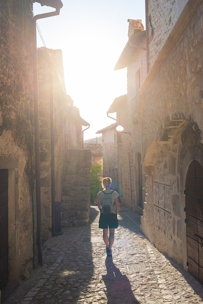 Tourist walking in Santo Stefano di Sessanio medieval village details, historical stone buildings, ancient alley, old city stone architecture. Abruzzo, Italy.