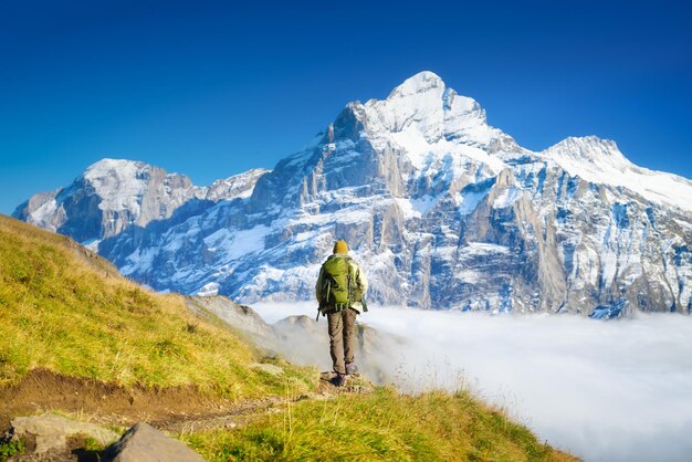 Tourist with a backpack in the mountains mountain hiking in the\
high mountains travel and adventure active life landscape in the\
summertime