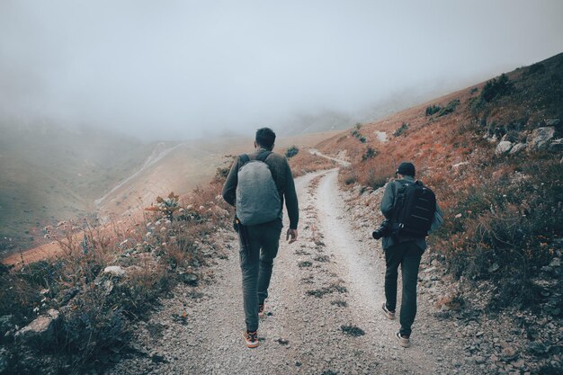 Tourist with a backpack walking in the mountains in the fog