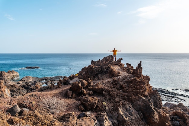Photo tourist with open arms on a volcanic trail on the beach of tacoron on el hierro canary islands concept of travel freedom