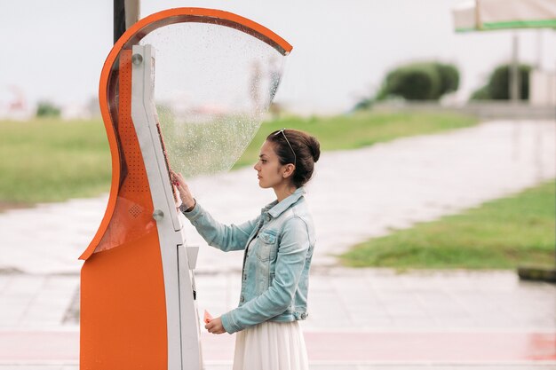 Tourist woman buys tickets for transport in Georgia. modern street machine for purchase of tickets for bus