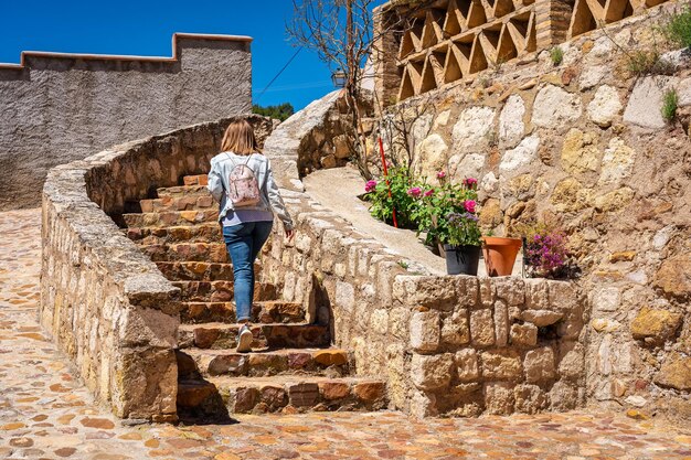 Tourist woman climbing some stairs that lead to the top of the monumental city of daroca zaragoza spain