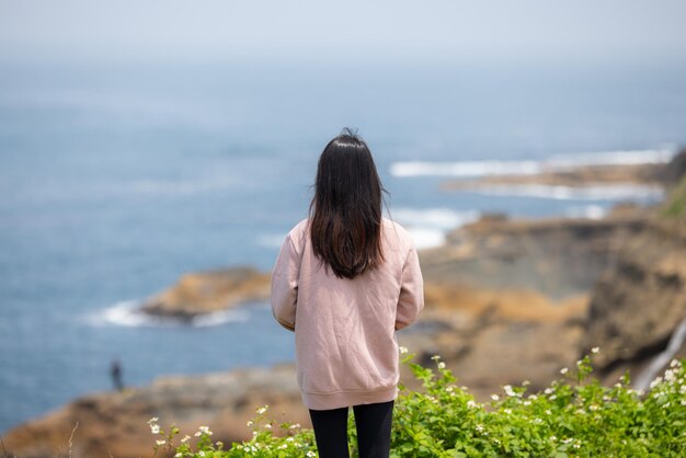 관광객 여성이 바다 전망을 즐기고 있습니다.