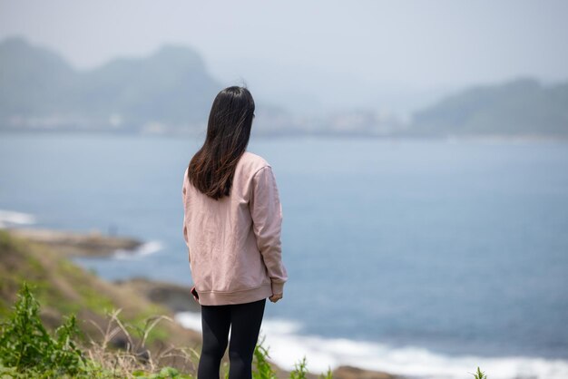 海の景色を楽しむ女性観光客