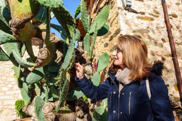 Tourist woman observing a large cactus in the town of madrid patones de arriba