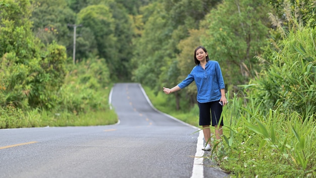 Autostoppista in piedi donna turistica per il viaggio.