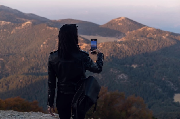 Tourist woman taking a mobile shot of mountains