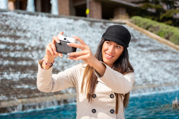 街で夏休みに写真カメラで自分撮りをしている観光客の女性