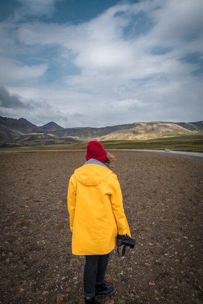 Tourist woman with camera standing near beautiful landscape