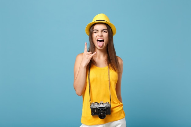 青の写真カメラと黄色の夏のカジュアルな服と帽子の観光客の女性