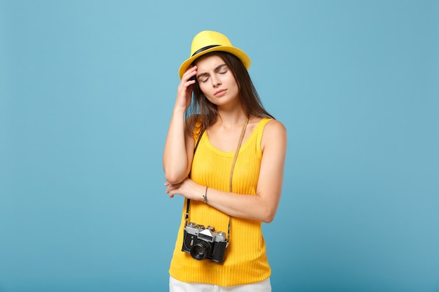 tourist woman in yellow summer casual clothes and hat with photo camera on blue