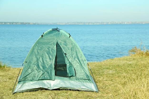 Touristic tent on dried grass near the river