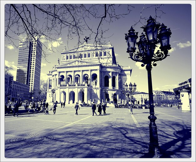 Tourists at alte oper against sky