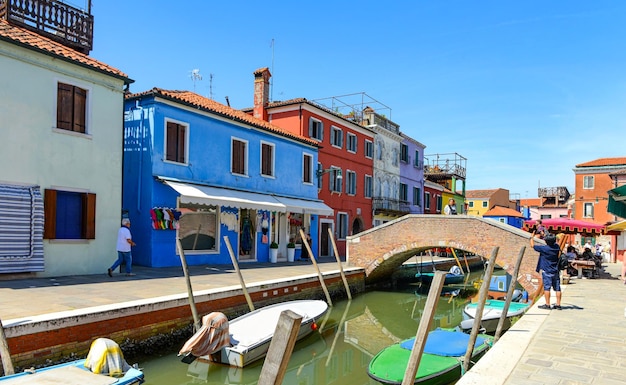 Tourists among the sovereign shops and restaurants on the main street of burano island