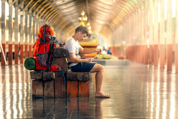 Tourists are working from the laptop at the train station while waiting for the train.