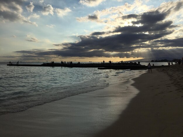 Tourists on beach at sunset