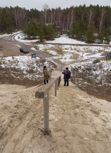 Tourists on Dunes of the Curonian Spit Lithuania under snow