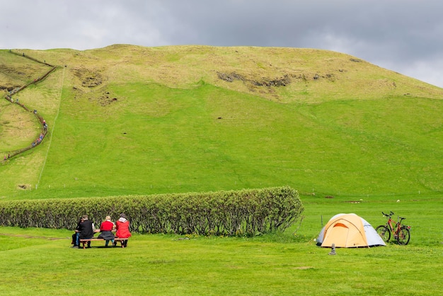 Tourists enjoy a picnic at Skogafoss Waterfall, Skogar, Iceland.