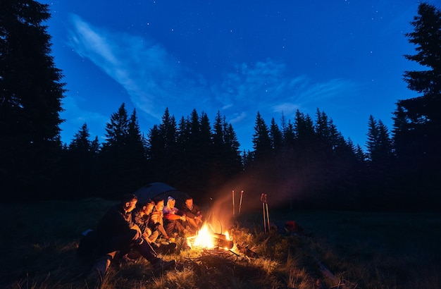 Turisti che si godono il tempo vicino al fuoco nella foresta