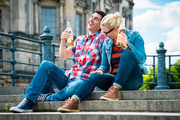 туристы наслаждаются видом с моста на Музейный остров в Берлине с пивом