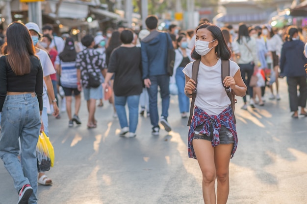 Tourists girls wearing face masks ar street.