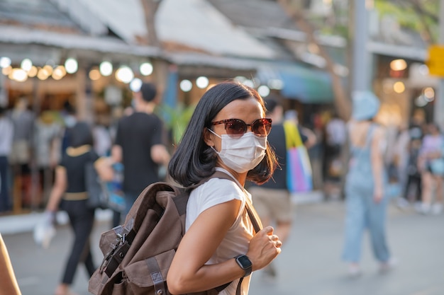 Tourists girls wearing face masks ar street.